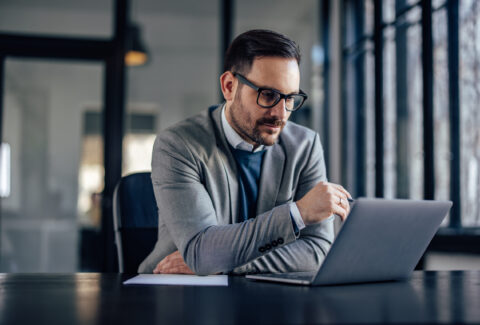 Concentrated caucasian businessman, reading his e-mails, on the laptop.